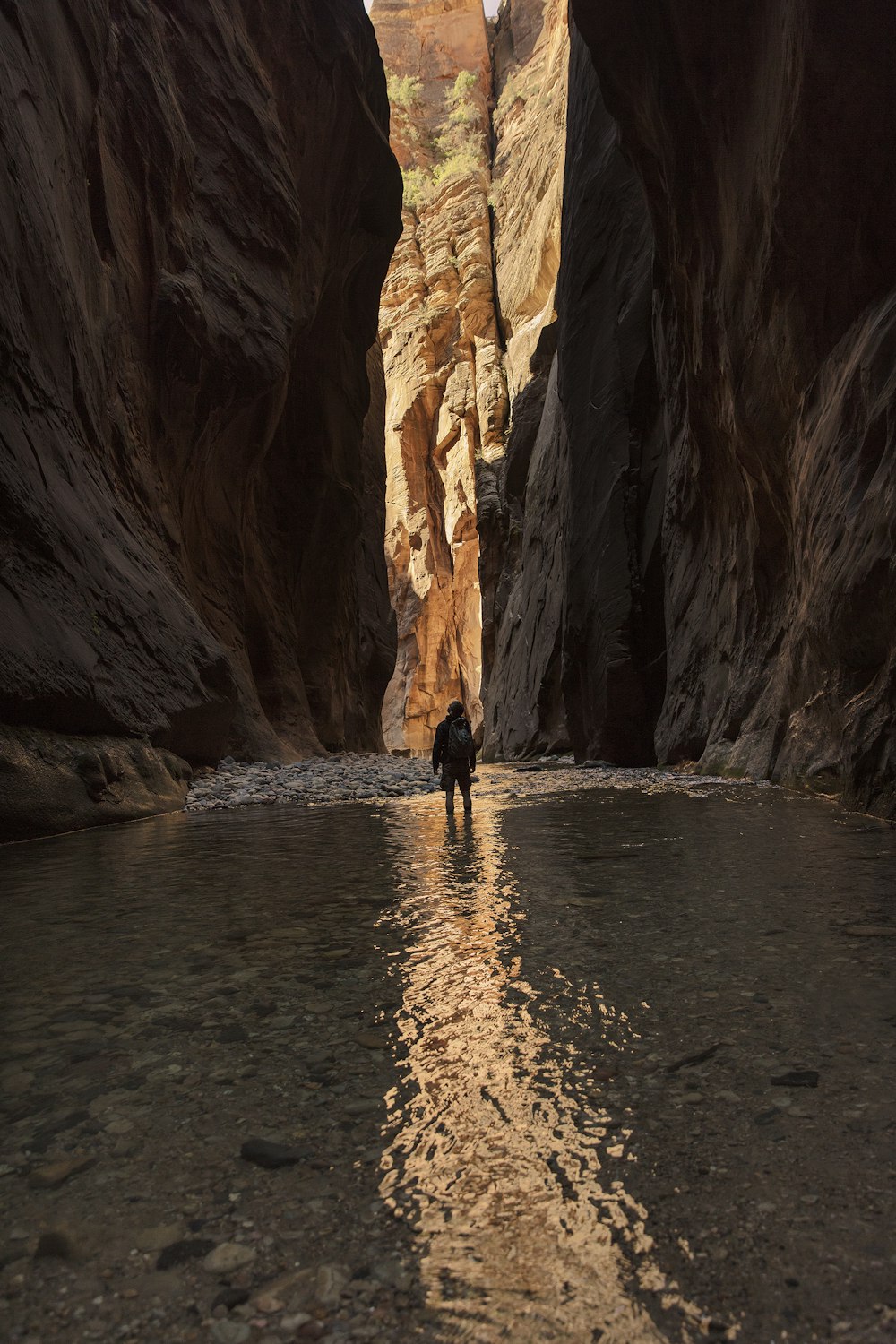 a person standing in the middle of a narrow canyon