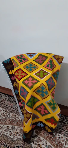 Brightly colored handwoven textiles draped over a chair.