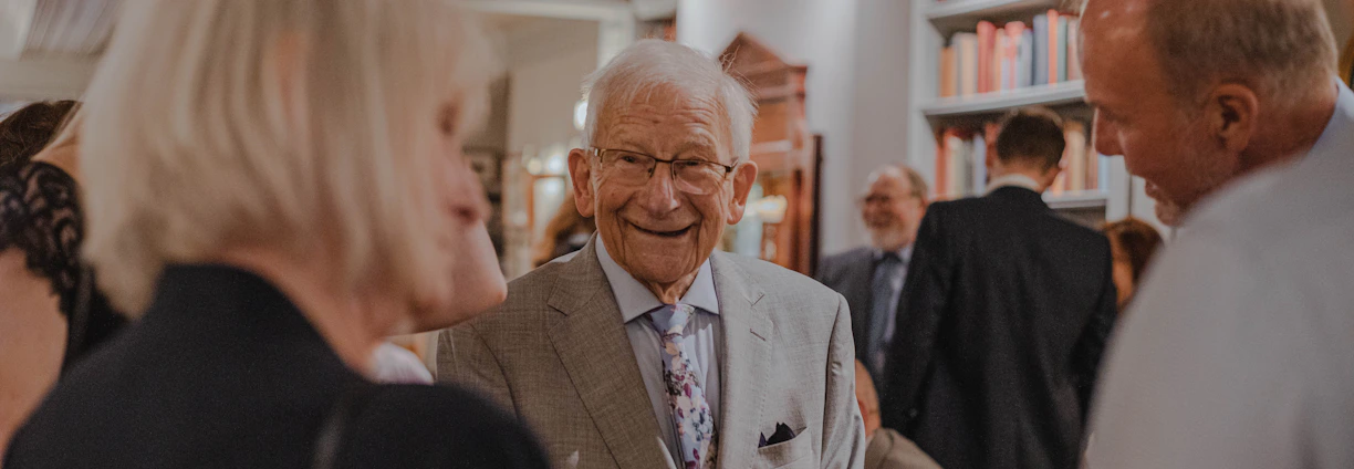smiling man wearing suit standing beside man