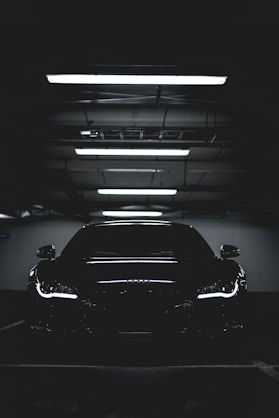 Carro preto estacionado mostrando o brilho da pintura sob luzes do teto - Estufa Originale