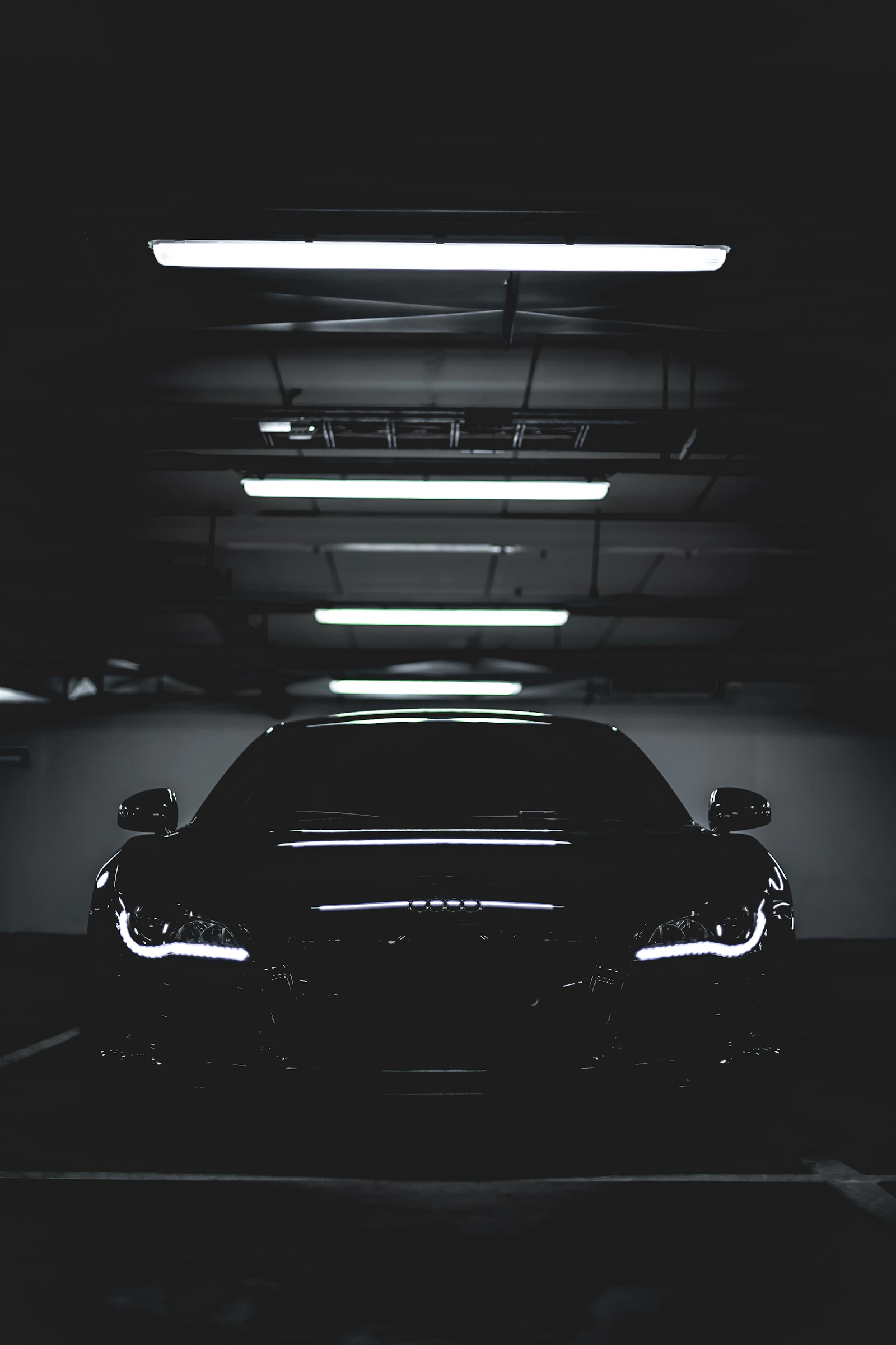 Black car under bright garage lights