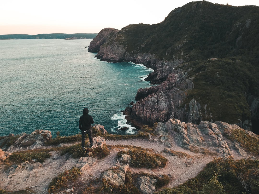 person standing on cliff during daytime