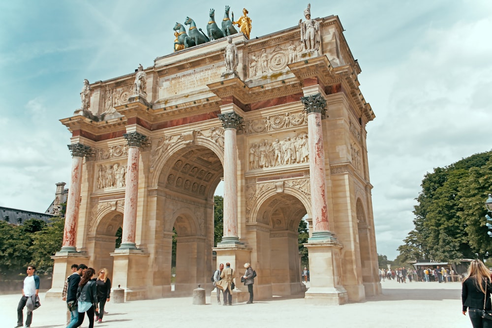 group of people walking near concrete arch