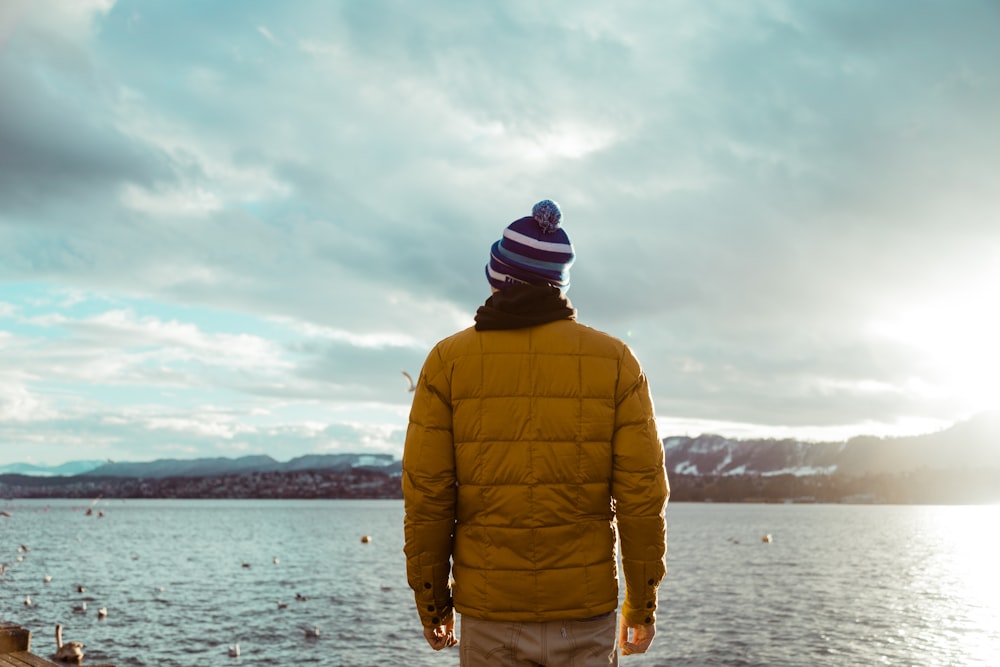 a man standing on a pier looking out at the water