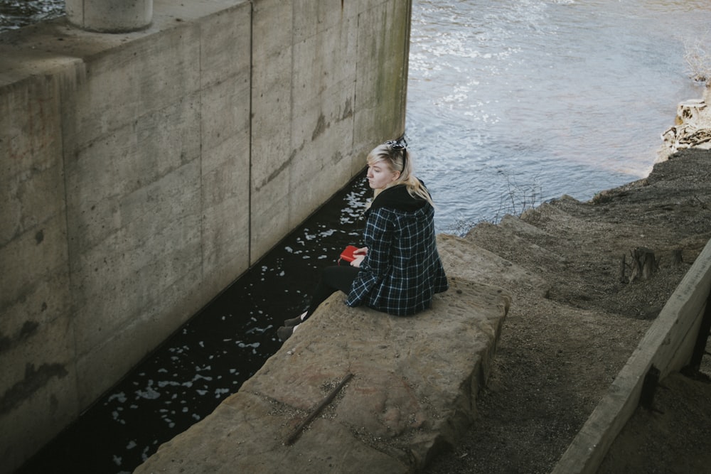 Mujer sentada junto al río