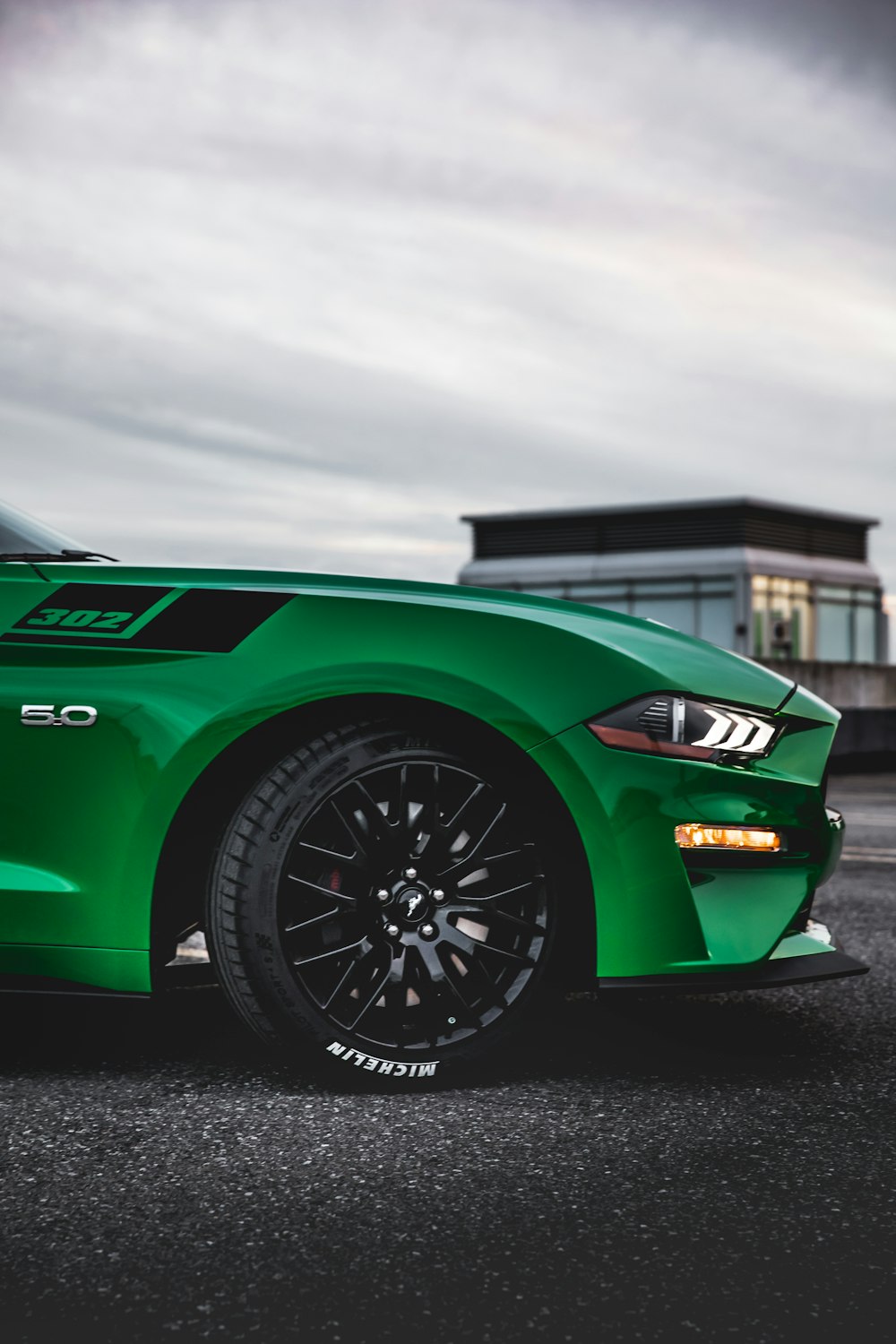 a green sports car parked in a parking lot