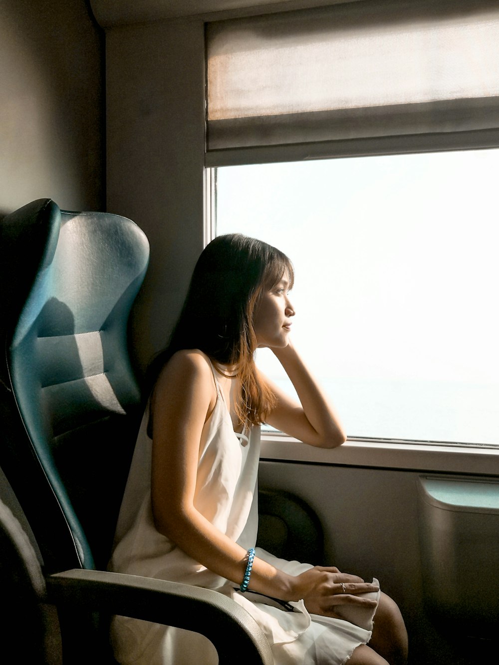 woman in white sleeveless dress looking at window