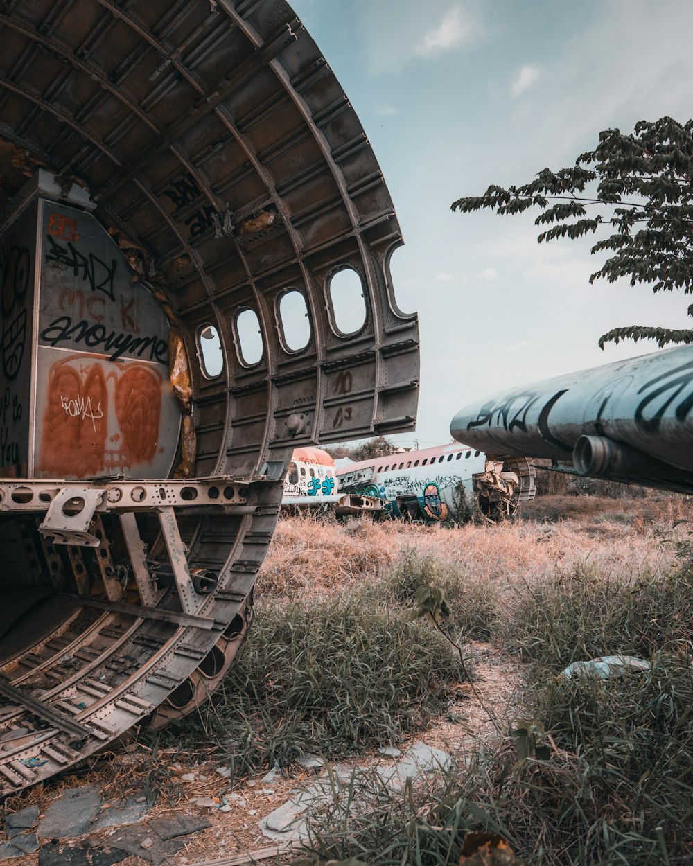 abandoned blue and orange airplane on field under blue and white skies during daytime