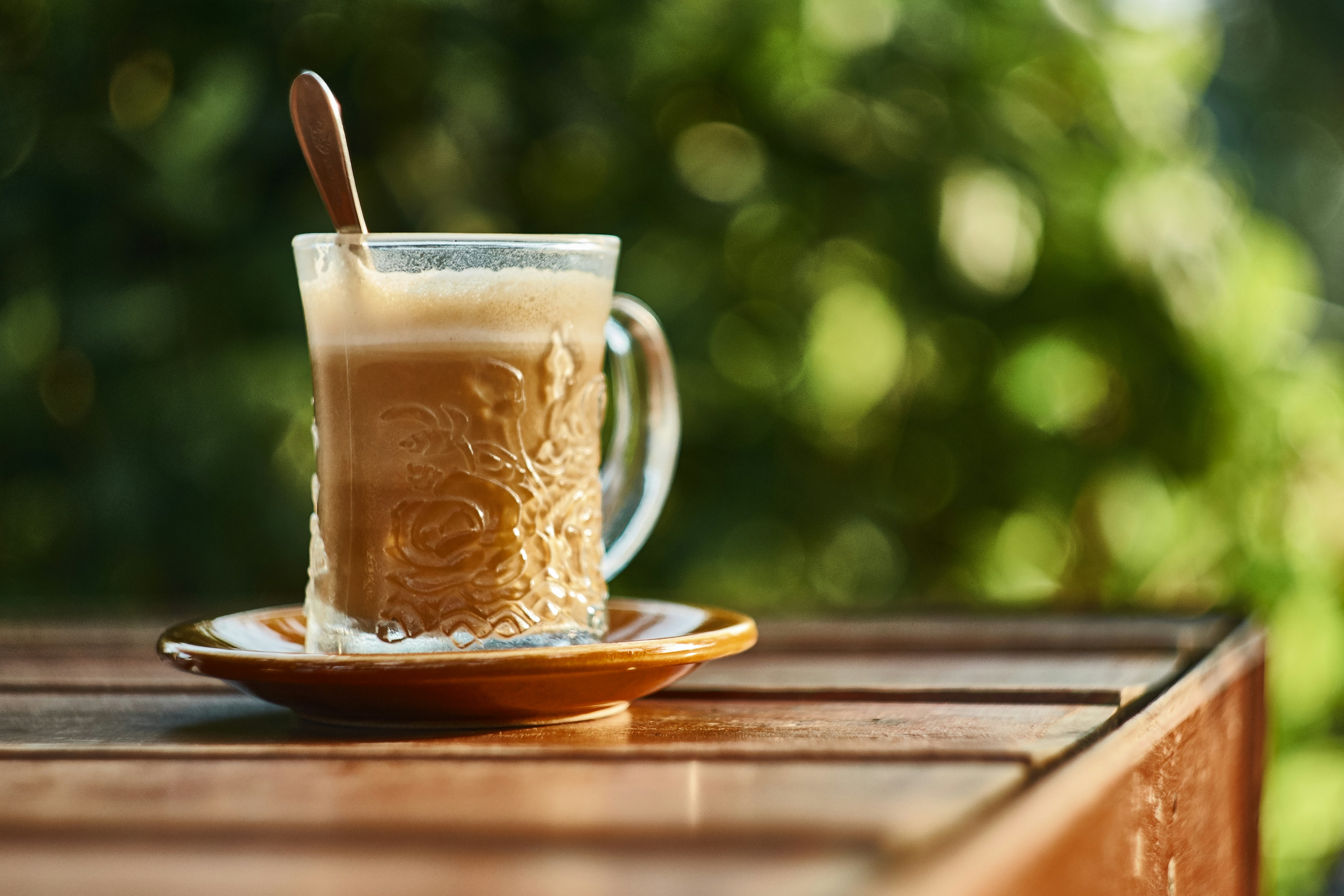Glass of milk coffee in sunlight