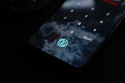 A smartphone screen displays a numeric keypad for password entry. There is a background resembling ocean waves and a circular fingerprint icon at the bottom.