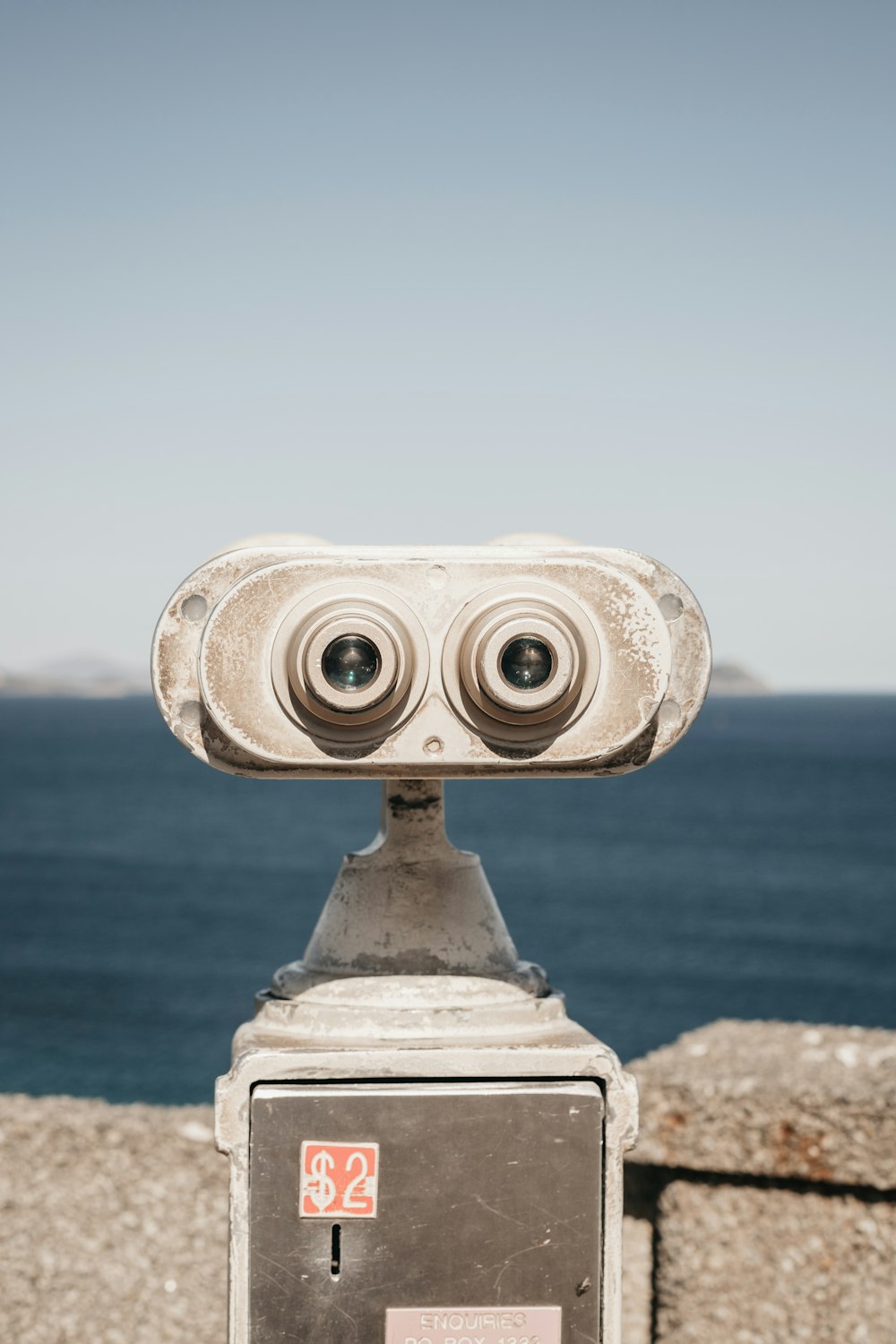 tower binoculars near body of water