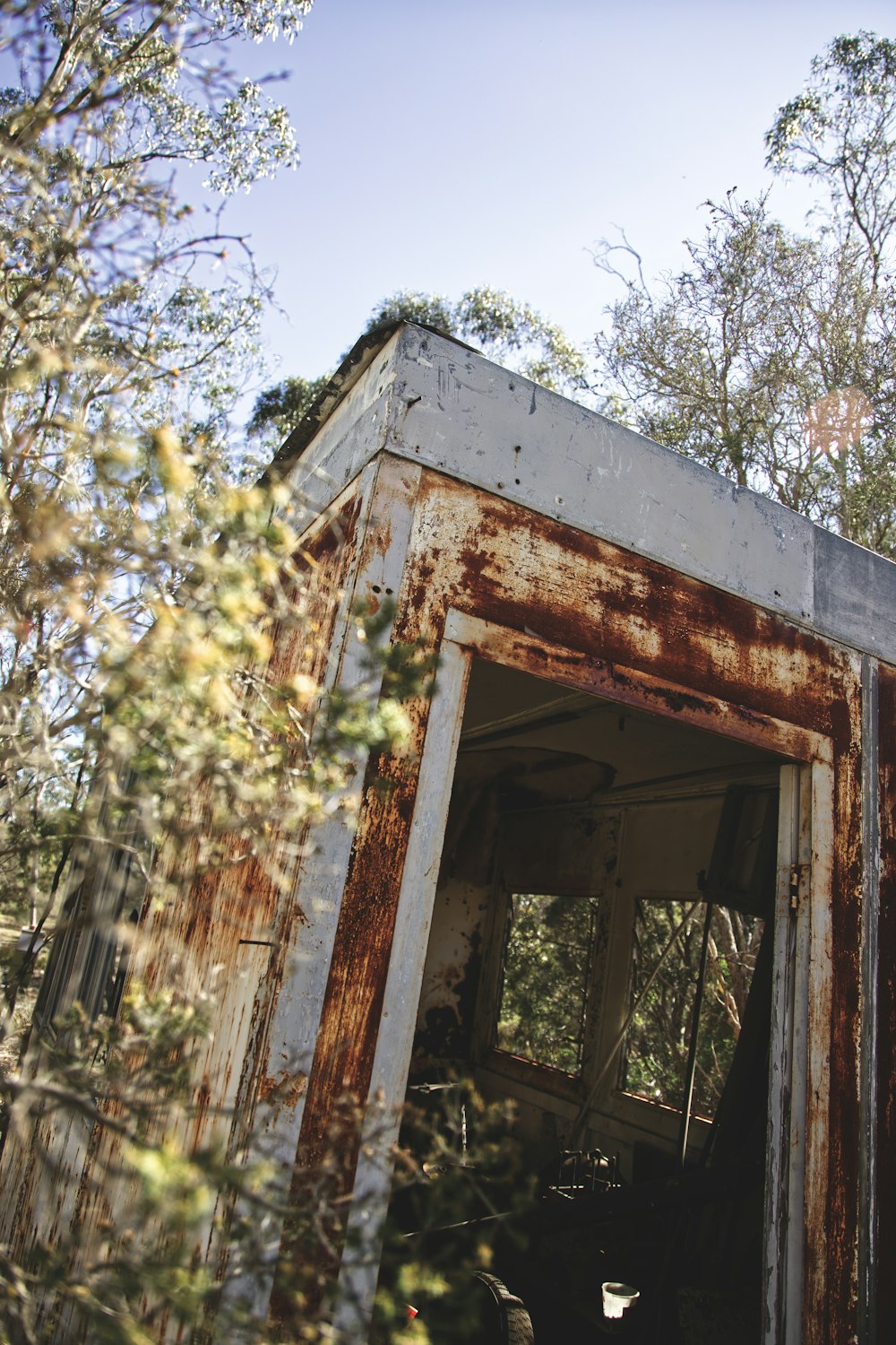 an old rusted out building in the woods