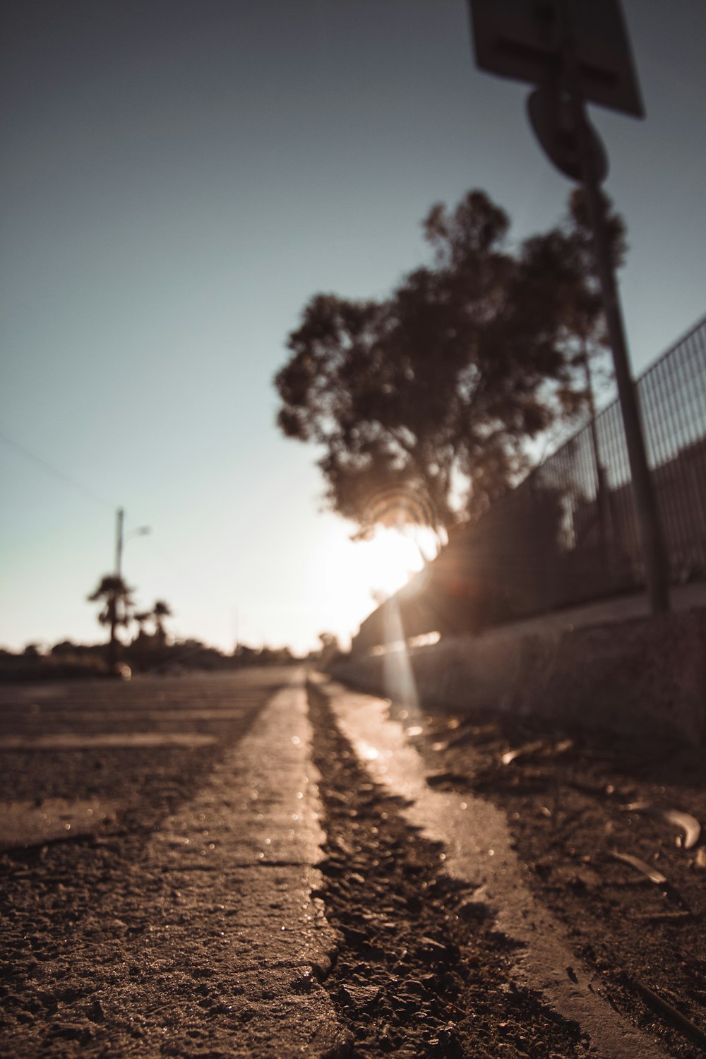 the sun is setting behind a street sign