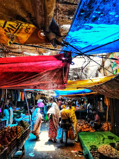 A vibrant market scene in Nouakchott with colorful stalls and bustling crowds under a bright sky.