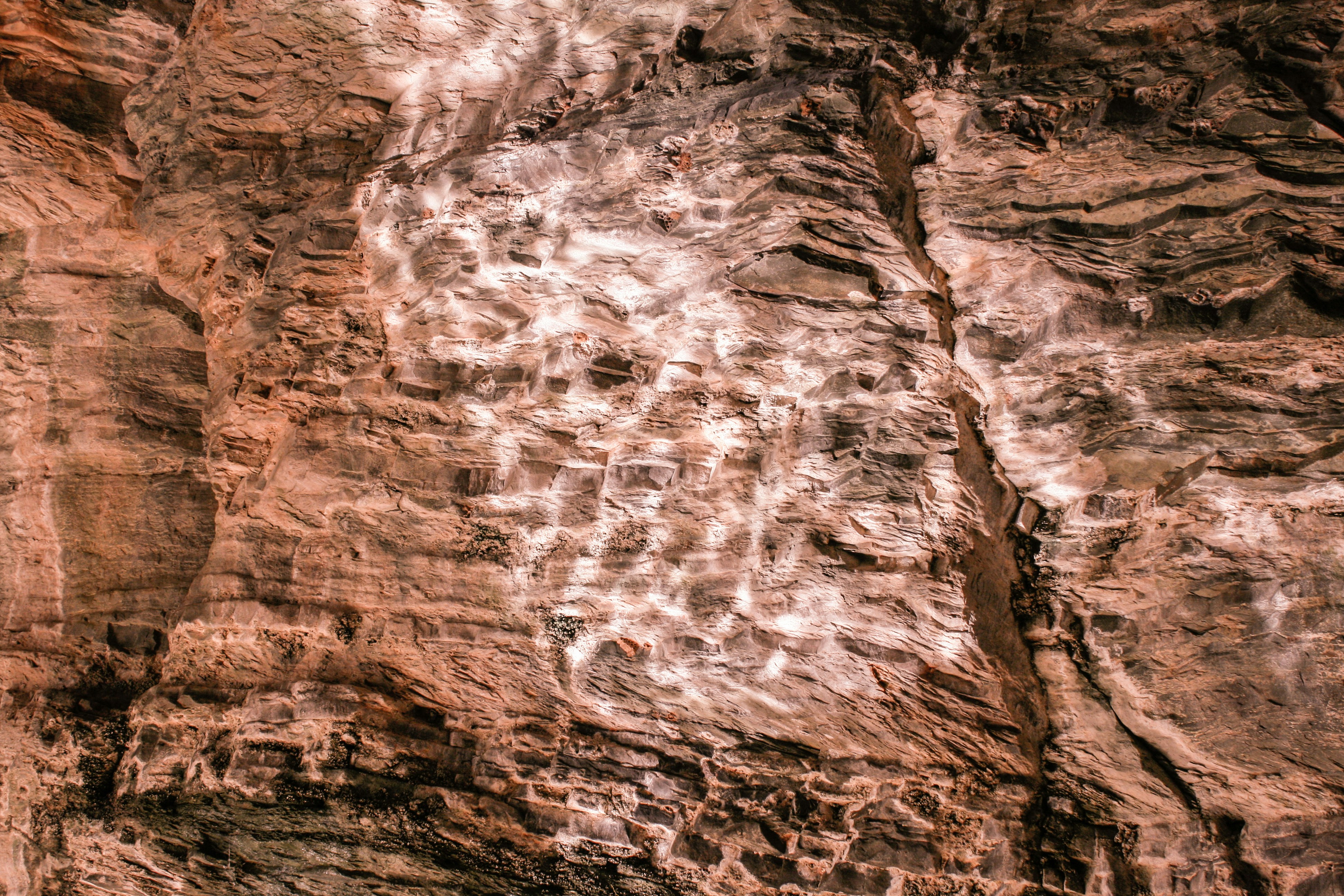 eine Person, die mit einem Surfbrett einen Berg hinaufklettert