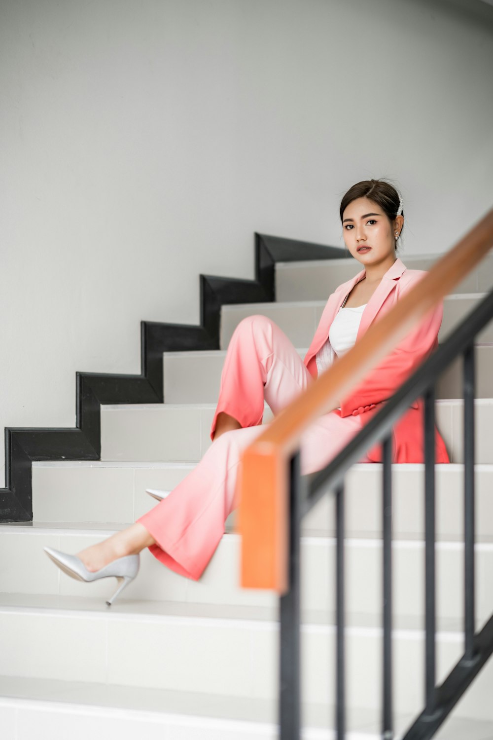 photo-shoot of woman wears pink formal attire sits on the stairs