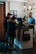 man and woman standing in front of man behind desk