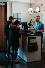 man and woman standing in front of man behind desk