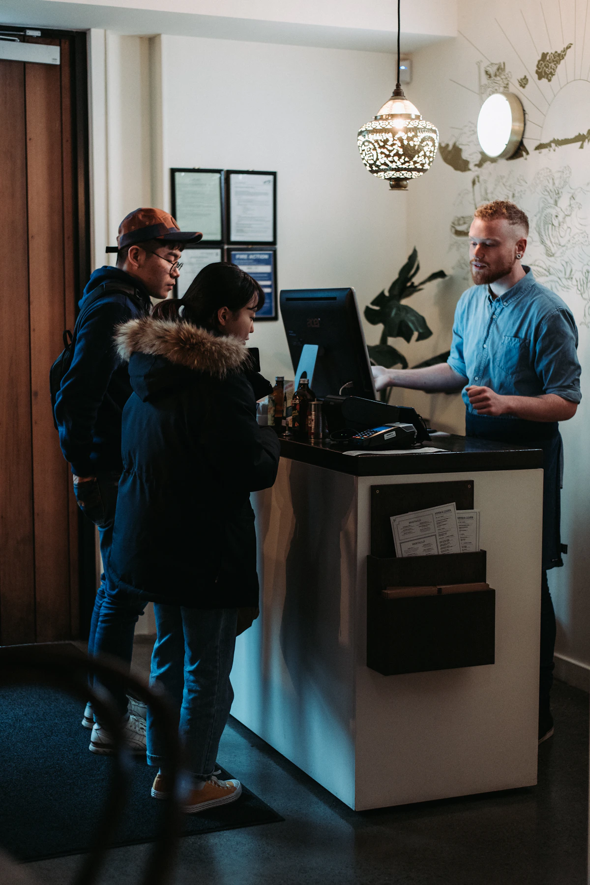 Guests being welcomed at a reception desk with Qey Pass