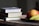 A stack of colorful books on a wooden table.