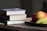stack of three books beside plate of fruits