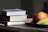 A stack of colorful books on a wooden table.