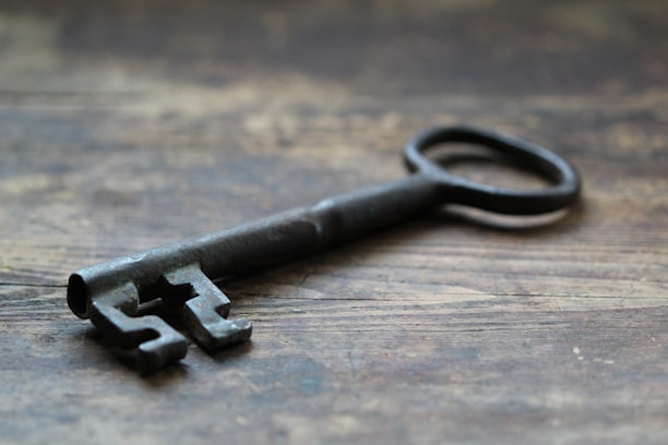 Close-up of a vintage key resting on an ancient wooden table in the donjon.