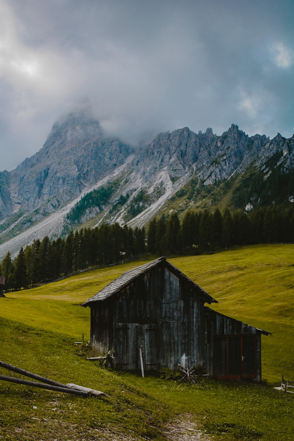 brown wooden house near mountain at daytime