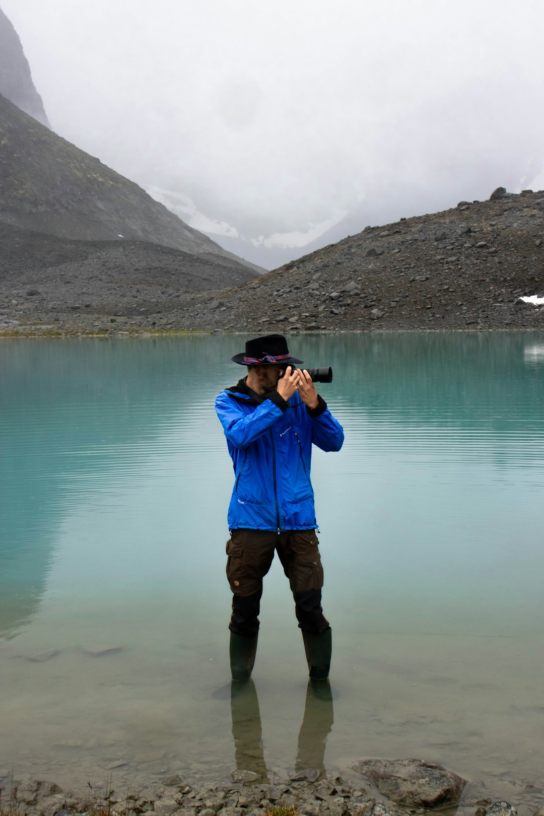 man standing on body of water using DSLR camera