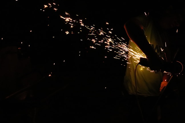 A craftsman using a power drill with sparks flying, showcasing tool strength.