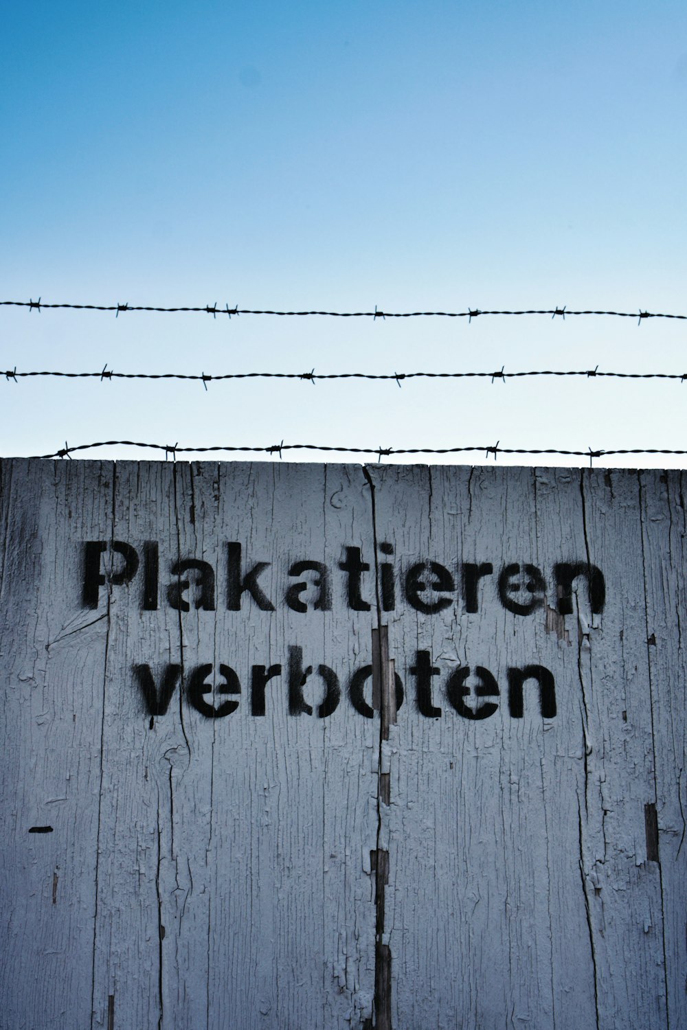 a wooden fence with barbed wire on top of it