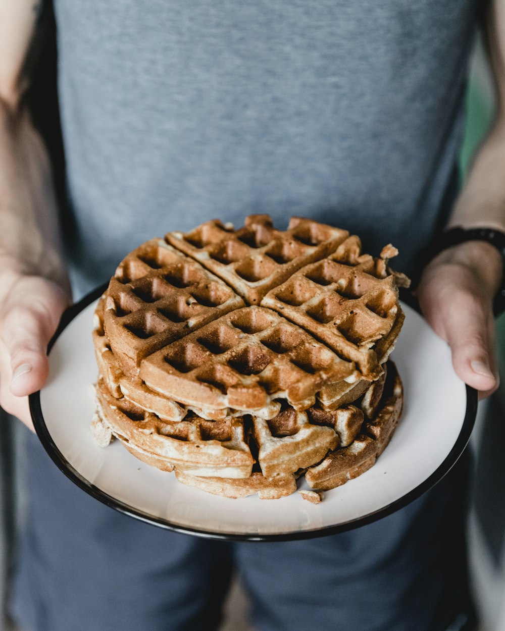 person holding plate with waffles