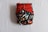 A colorful diaper with a space-themed pattern featuring rockets and stars, accented with red and black snap buttons on the front. The background is predominantly black with vibrant illustrations.
