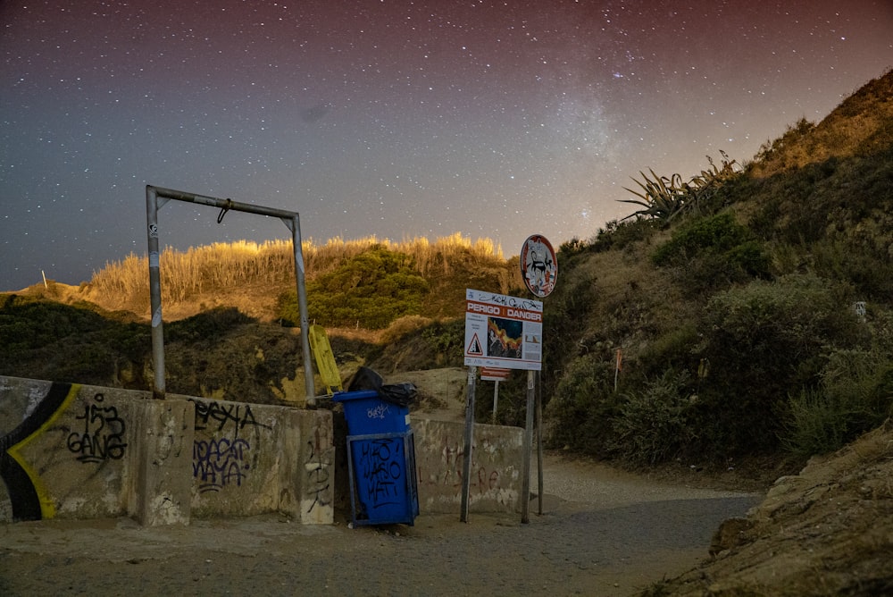 red and white sign near wooden fence during starry night