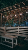Outdoor patio space with string lights, potted plants, and a reclaimed wood dining table.