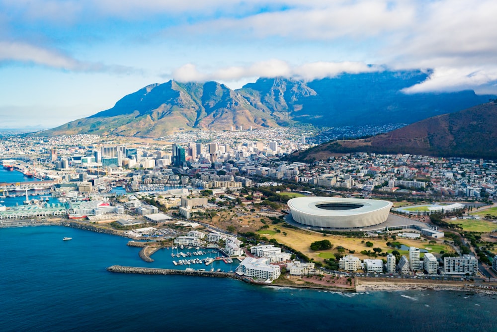 photo of mountain and buildings nearby at seashore scenery