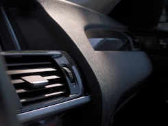 Close-up of a technician carefully cleaning a car's interior dashboard