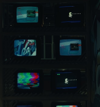 a bunch of tvs that are sitting on a shelf