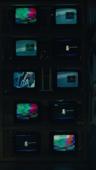 a bunch of tvs that are sitting on a shelf