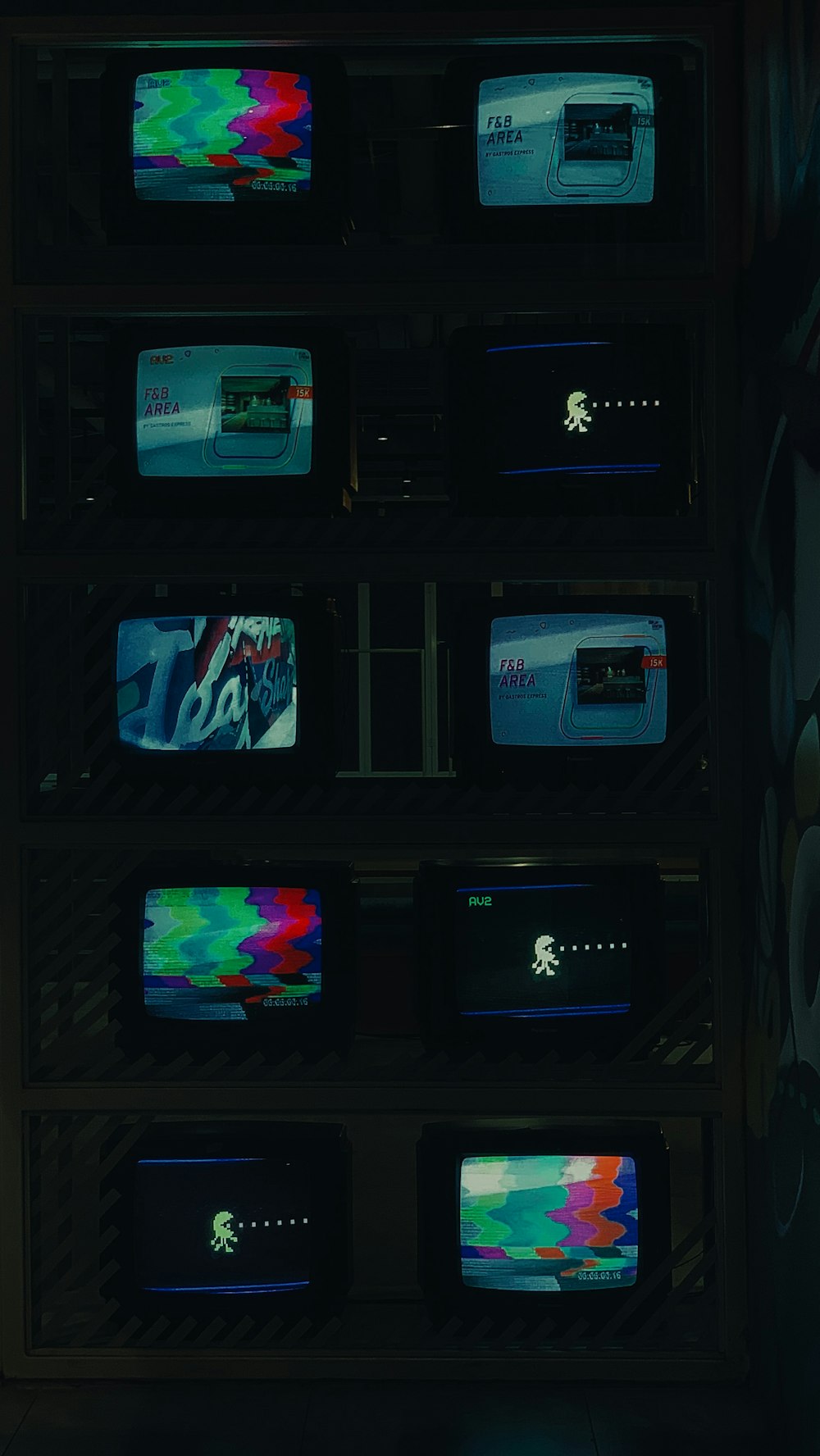 um monte de TVs que estão sentadas em uma prateleira