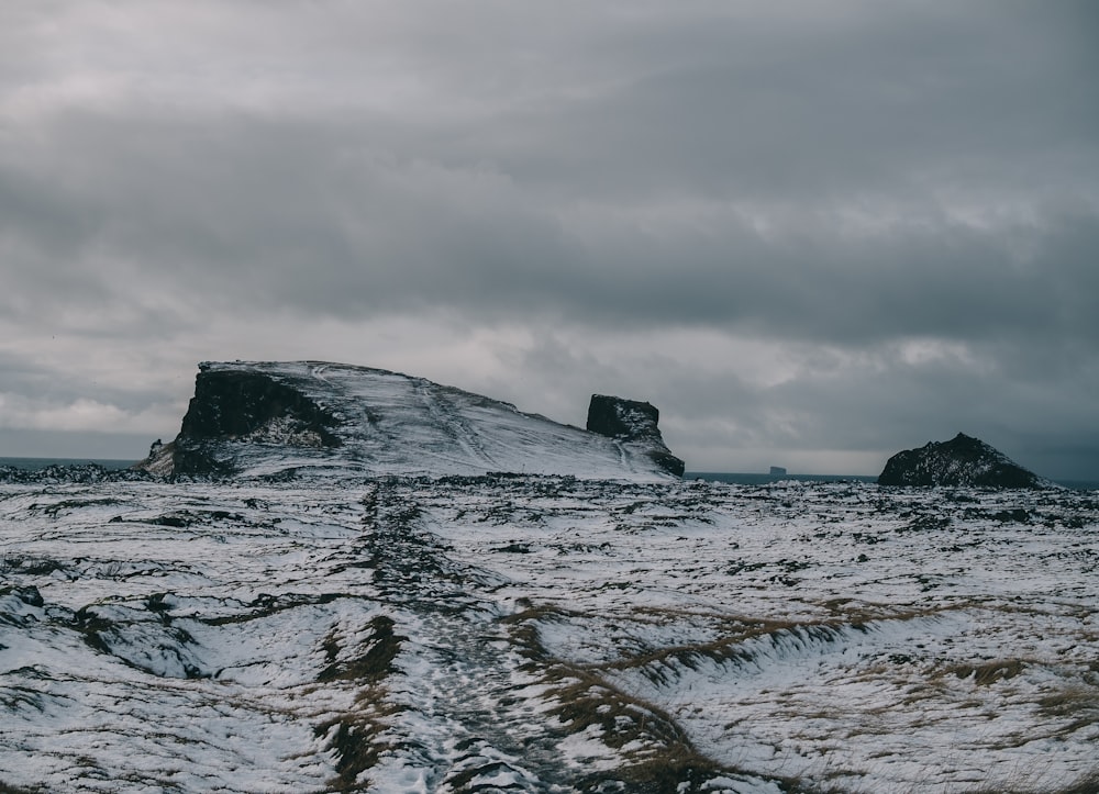 field and mountain covered with snow during daytime