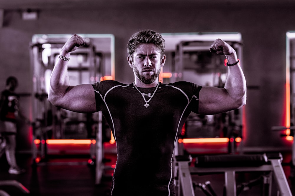 man flexing his biceps inside gym
