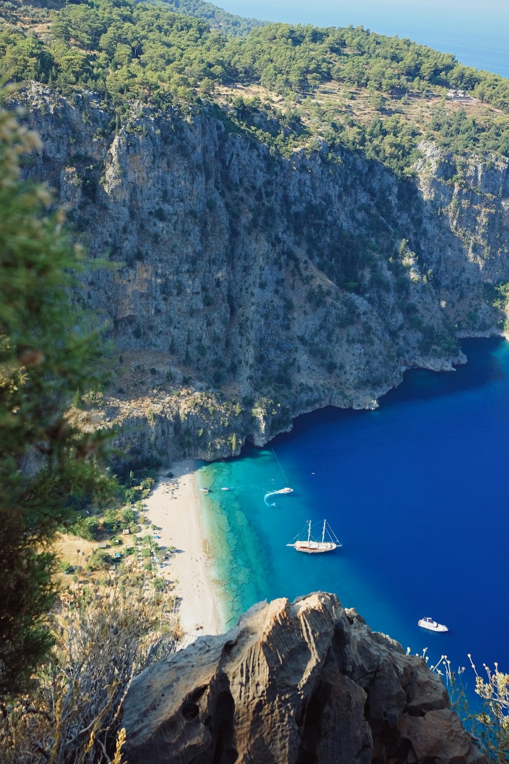 aerial photography of boats on blue sea viewing mountain during daytime