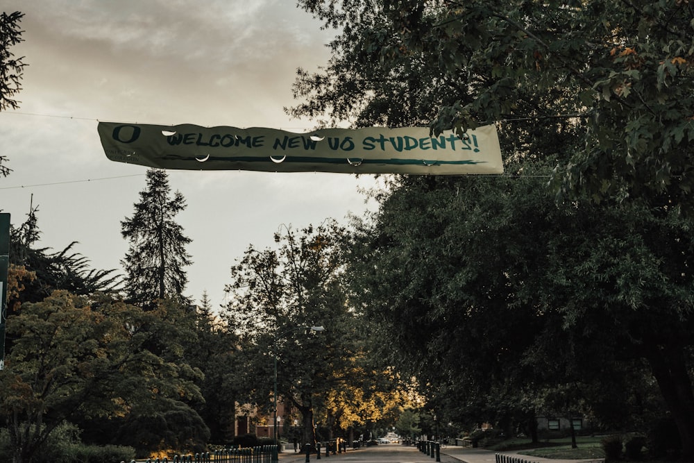 welcome new students tarpaulin near trees