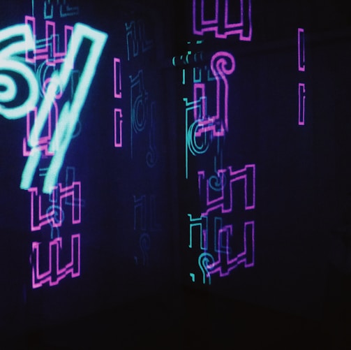 neon signs are lit up in a dark room