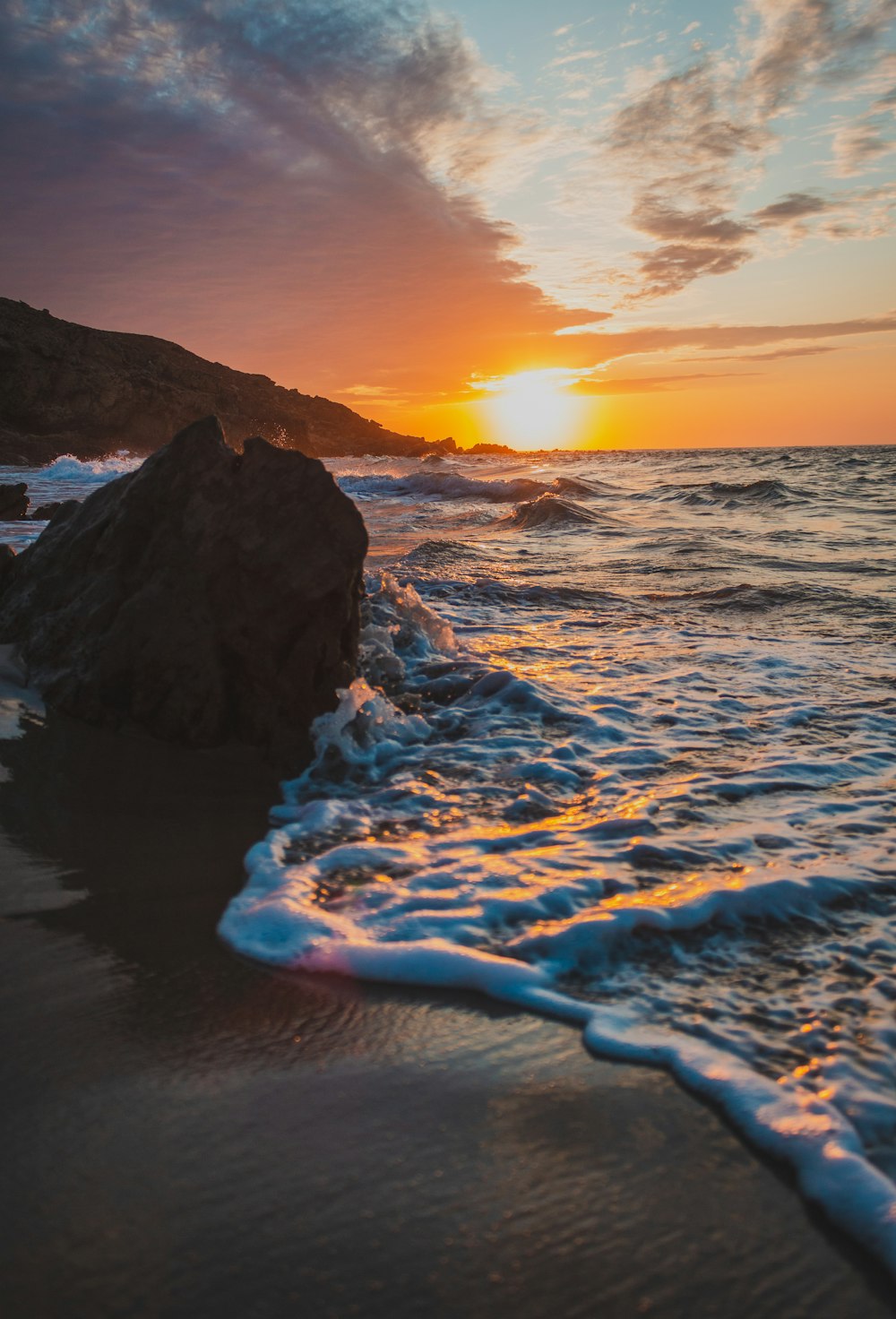 waves crashing on coastal rock during golden hour