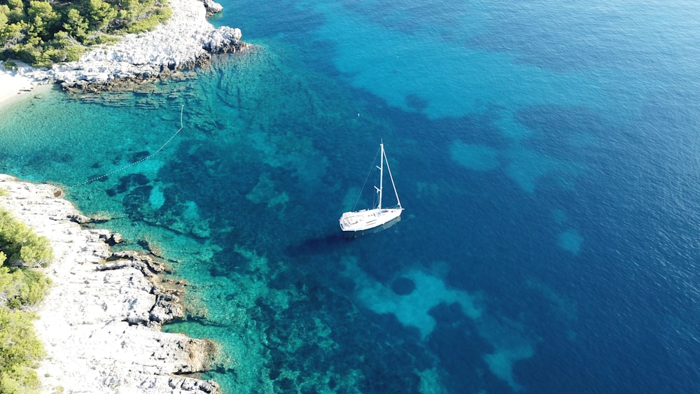 white boat on calm water at daytime