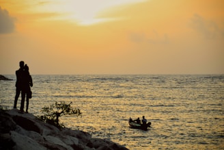 A couple enjoying a private boat ride at sunset along the golden beaches of the Bay of Bengal.