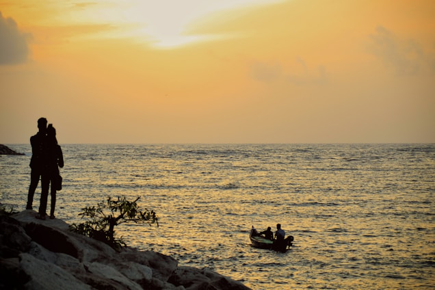 A couple enjoying a private boat ride at sunset along the golden beaches of the Bay of Bengal.