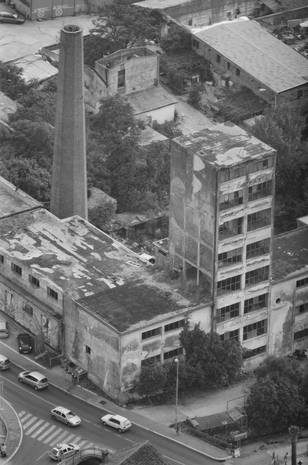 grayscale photography of vehicles near buildings